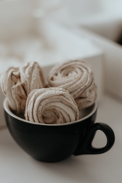 Brown ceramic cup with brown and white sugar
